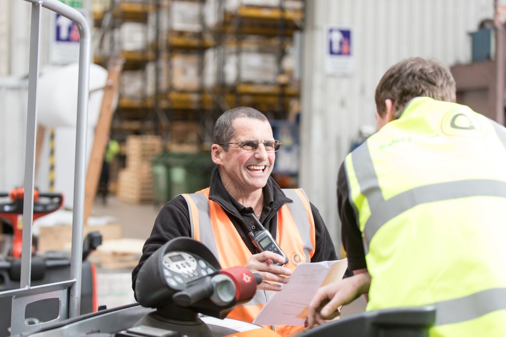 two people in warehouse chatting.